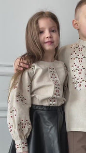 Child wearing traditional Ukrainian embroidered shirt with intricate patterns, smiling. Ideal for cultural events and celebrations.