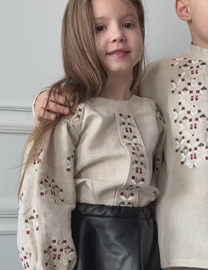 Child wearing traditional Ukrainian embroidered shirt with intricate patterns, smiling. Ideal for cultural events and celebrations.