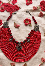 Traditional Ukrainian red bead necklace with crosses, featuring glass and acrylic beads, bronze metal fittings, on embroidered fabric.