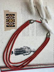 Red ceramic beaded necklace in Hutsul style, showcasing Ukrainian ethnic craftsmanship, laid on a traditional artistic background.
