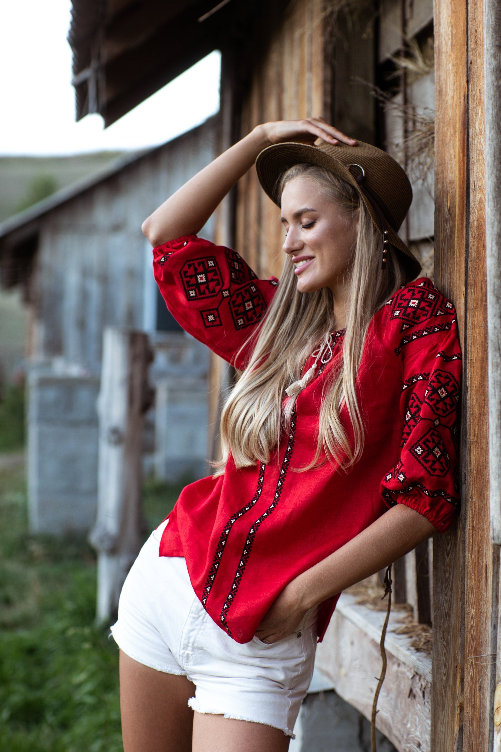 Woman wearing a red linen embroidered Ukrainian vyshyvanka blouse, showcasing traditional folk design and cultural heritage.