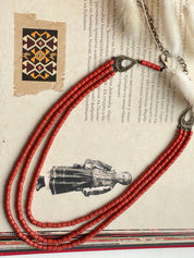 Red ceramic beaded necklace showcasing traditional Hutsul style on a vintage Ukrainian background.