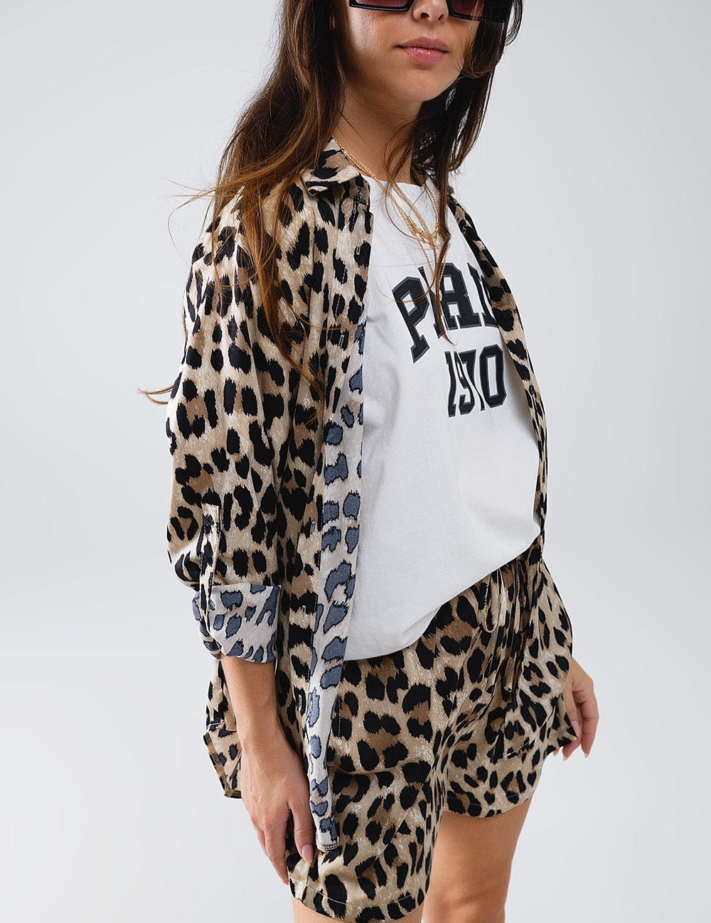Woman wearing Thavari High-Low Leopard Shirt with matching shorts, featuring a flowing oversized design and classic polo collar.
