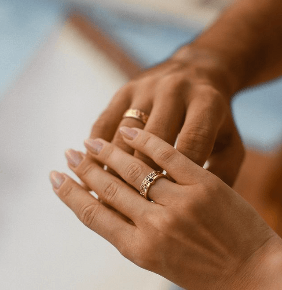 Close-up of two hands with elegant rings on fingers, highlighting detailed design and craftsmanship.