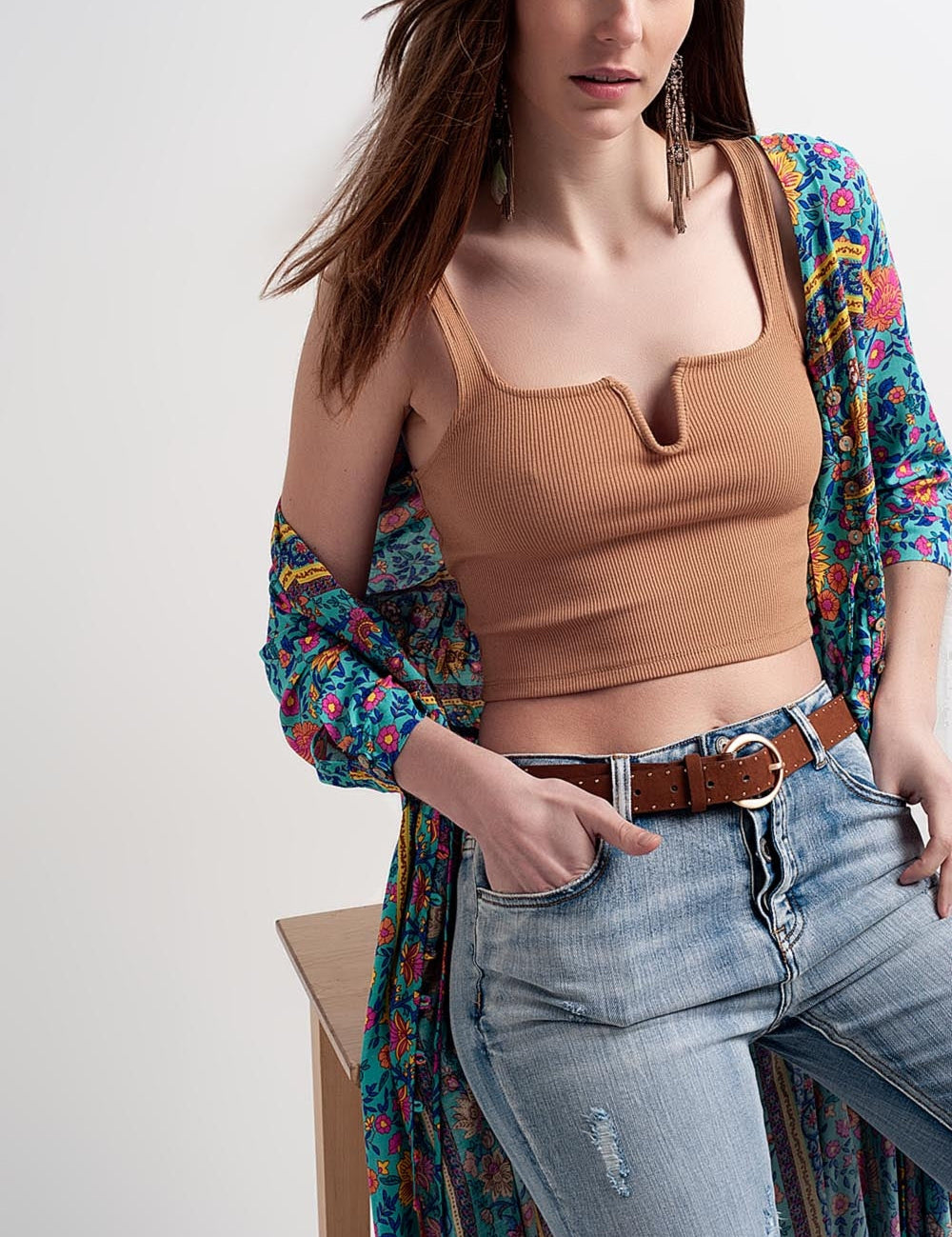 Model wearing Aurette Ribbed Crop Top with V-neck in stretch cotton, paired with distressed jeans and colorful robe.