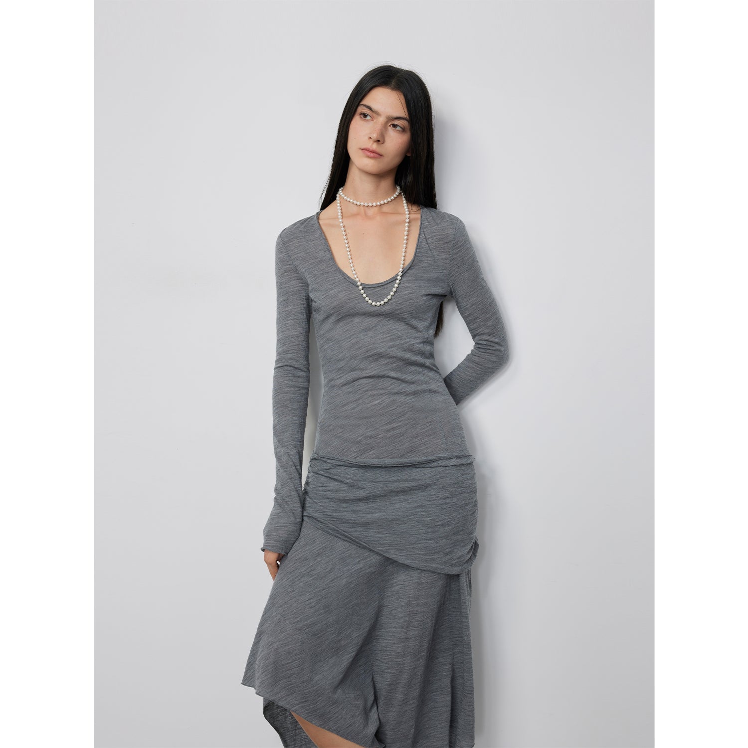 Woman wearing Serelis Merino Wool Drape Dress with U-neck and flowing skirt, showcasing its elegant silhouette and architectural design.