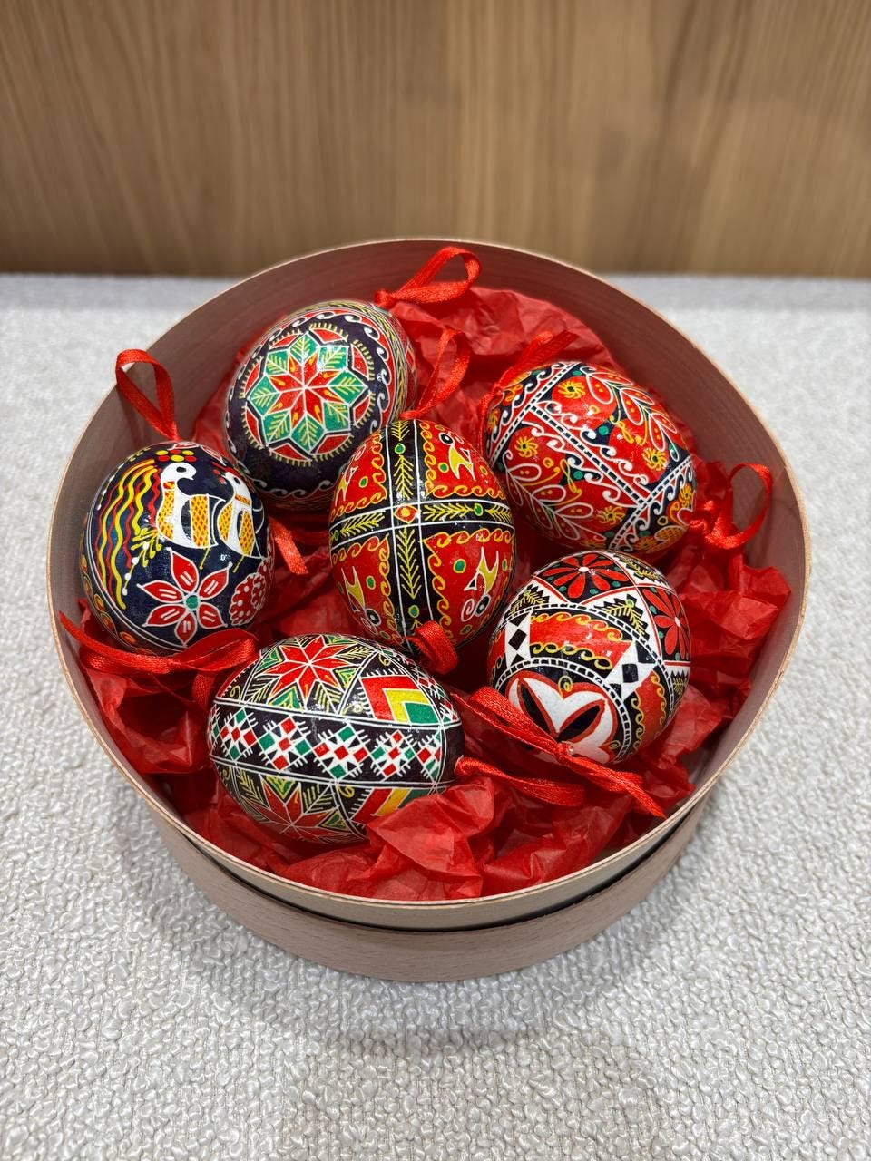 Set of 6 Ukrainian Pysanky Easter eggs in a basket, hand-painted with traditional folk patterns on real chicken eggshells.