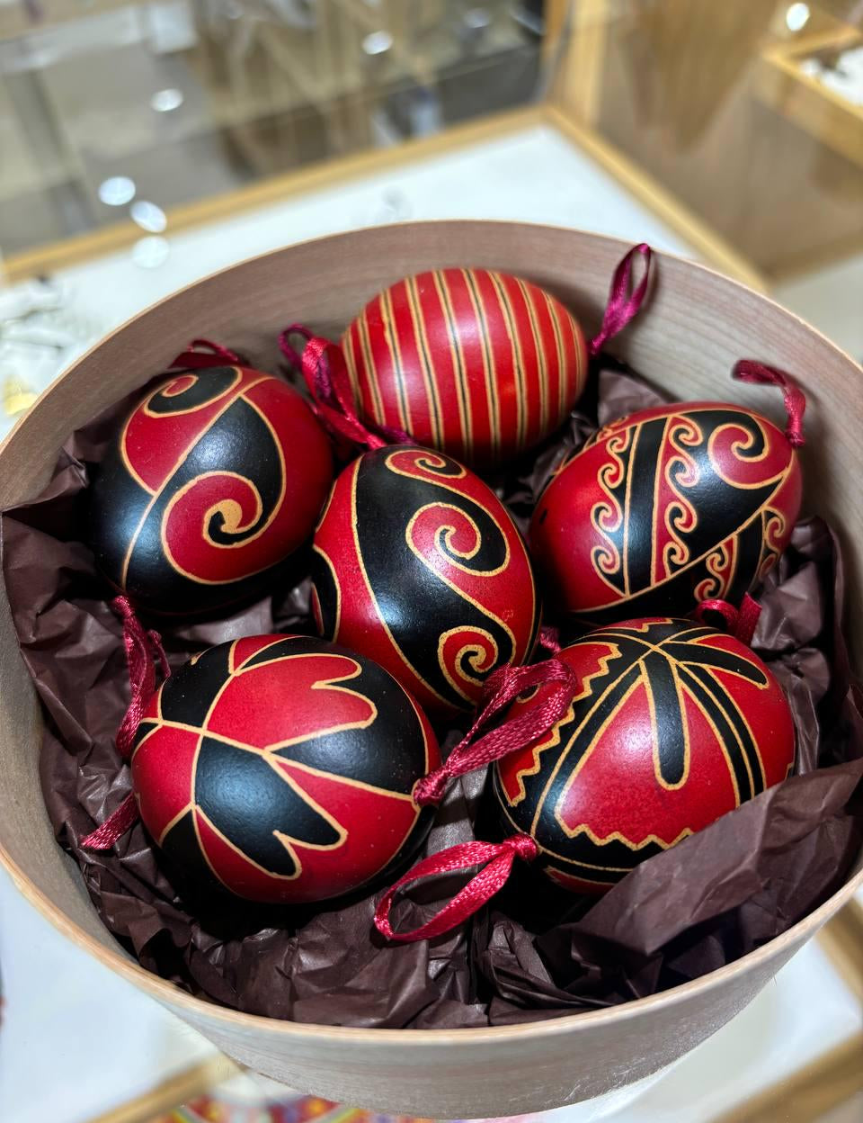 Set of 6 handmade Ukrainian Pysanky in a bowl, featuring red and black traditional folk art designs on real chicken eggs.