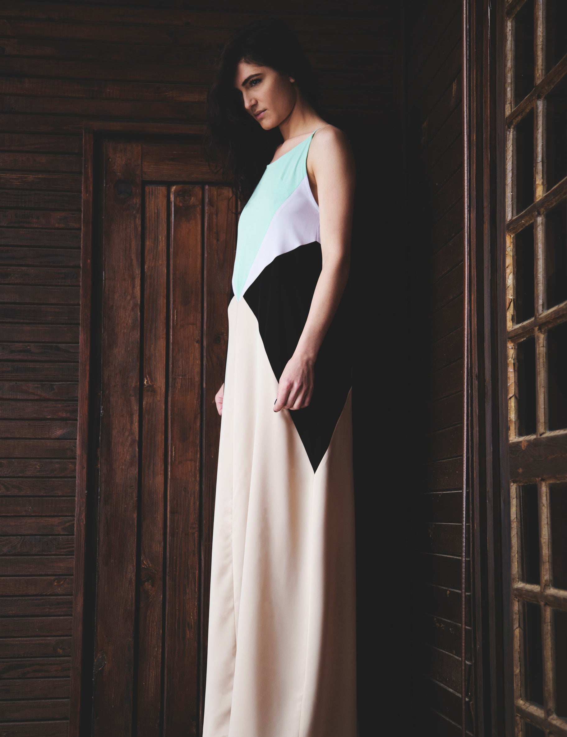 Model in Modernist Muse Maxi Dress with geometric panels in black, lavender, mint green, and cream, featuring clean lines and bold style.