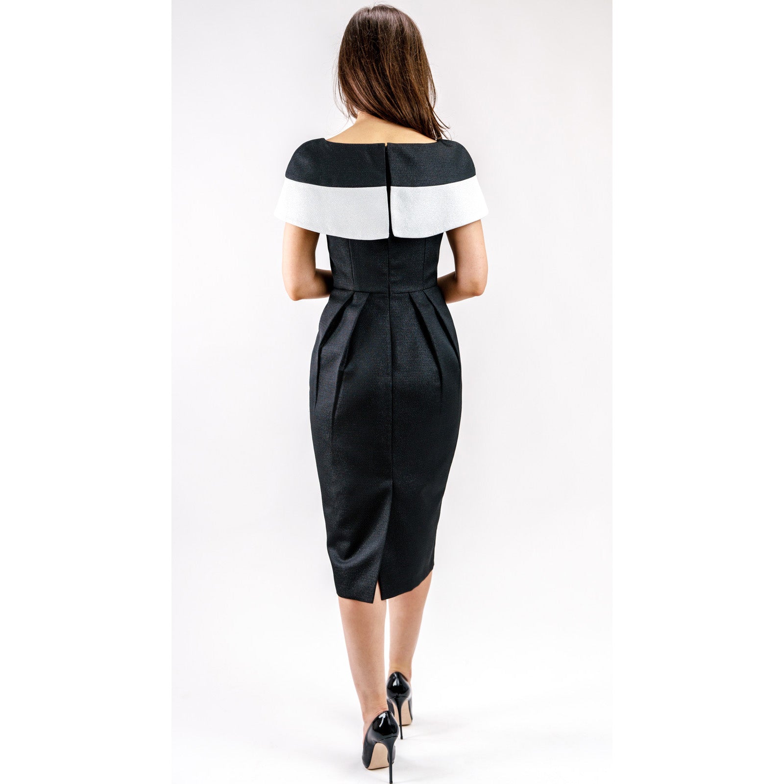 Rear view of a woman wearing a Marcelline Contrast-Collar Midi Dress, featuring a black and white neckline and shimmering French jacquard.