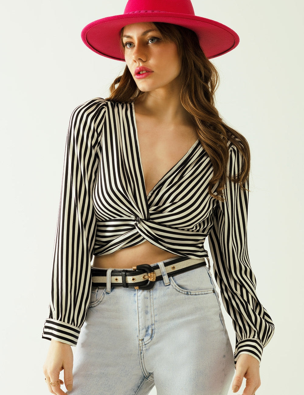 Woman wearing the Nivarra Twisted Satin Crop Top with black-and-white stripes, featuring a deep V-neck and twisted front detail.