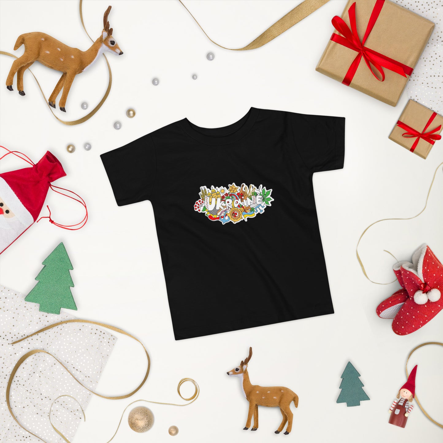 Toddler black t-shirt with colorful Ukraine design, surrounded by festive decorations and gifts on a white background.