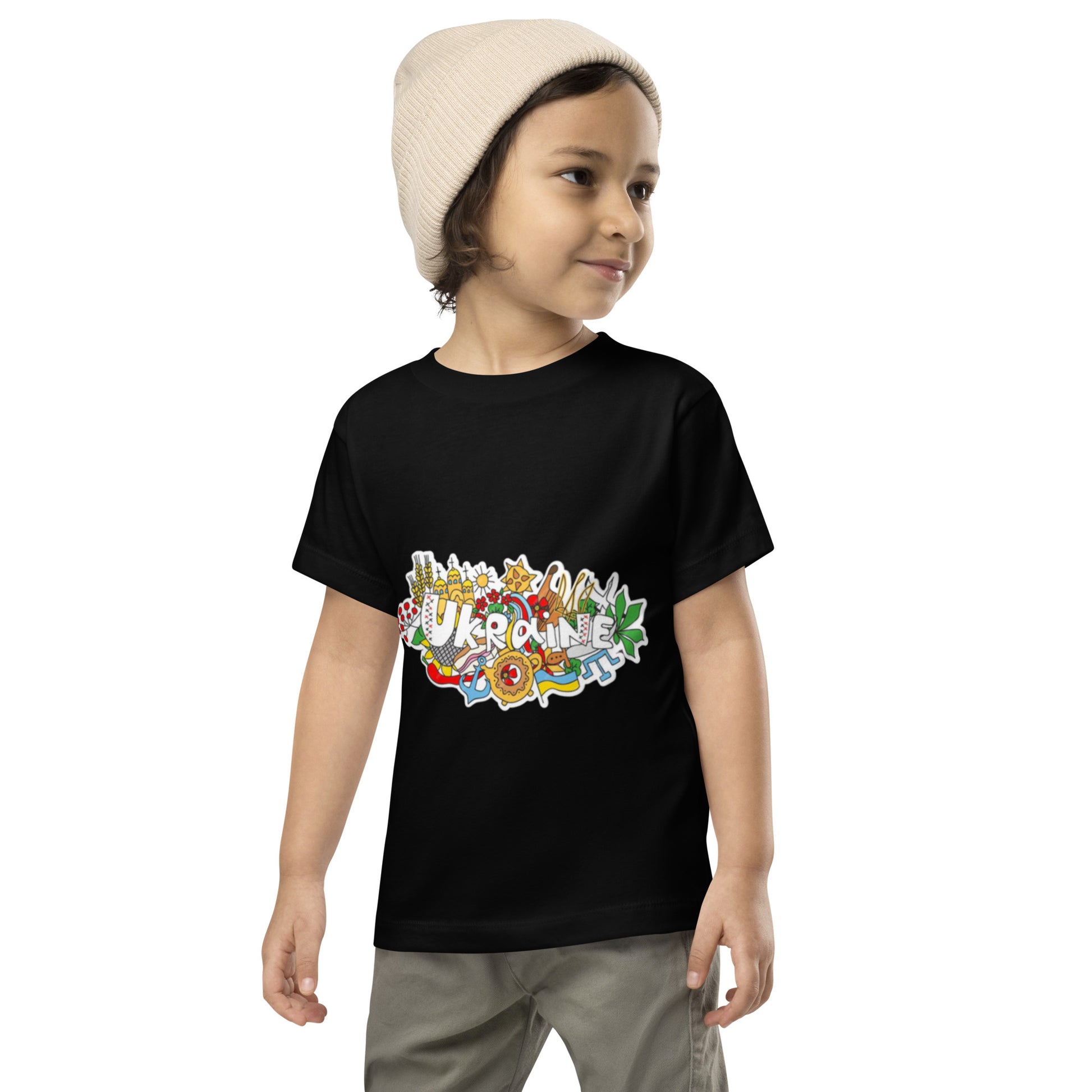 Toddler wearing Ukraine design short sleeve t-shirt, 100% cotton, in black, showcasing vibrant cultural print, perfect for playtime.