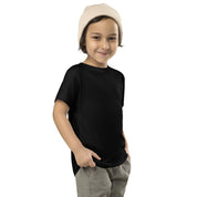 Toddler wearing black short-sleeve tee with Ukrainian Tryzub print, complemented by a cozy beanie and casual pants.