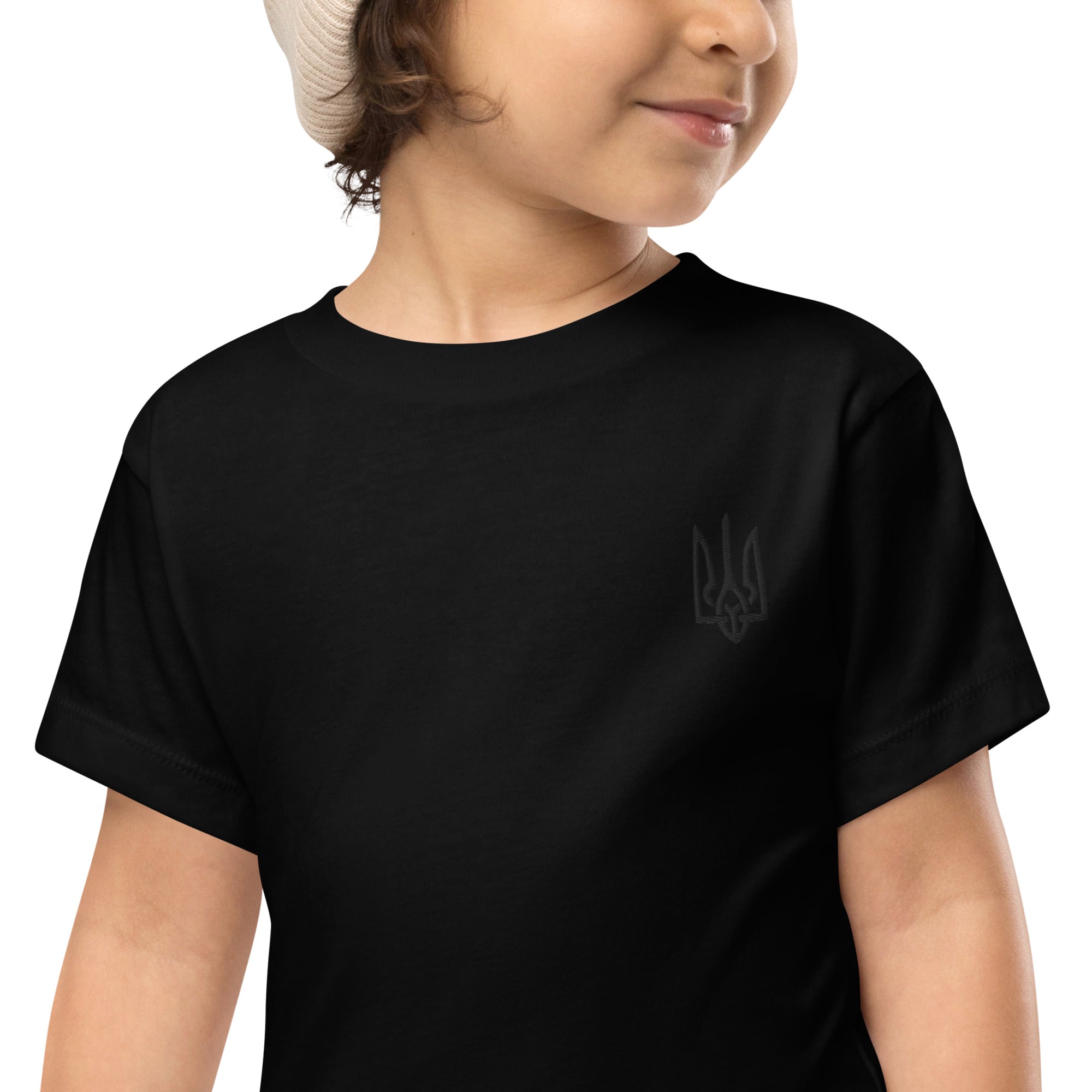 Toddler wearing black short sleeve tee with Ukrainian Tryzub design, made from 100% cotton for comfort and durability.