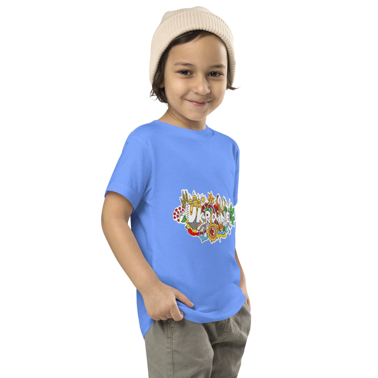 Toddler wearing blue short sleeve T-shirt with Ukraine-inspired design, smiling and posing confidently.