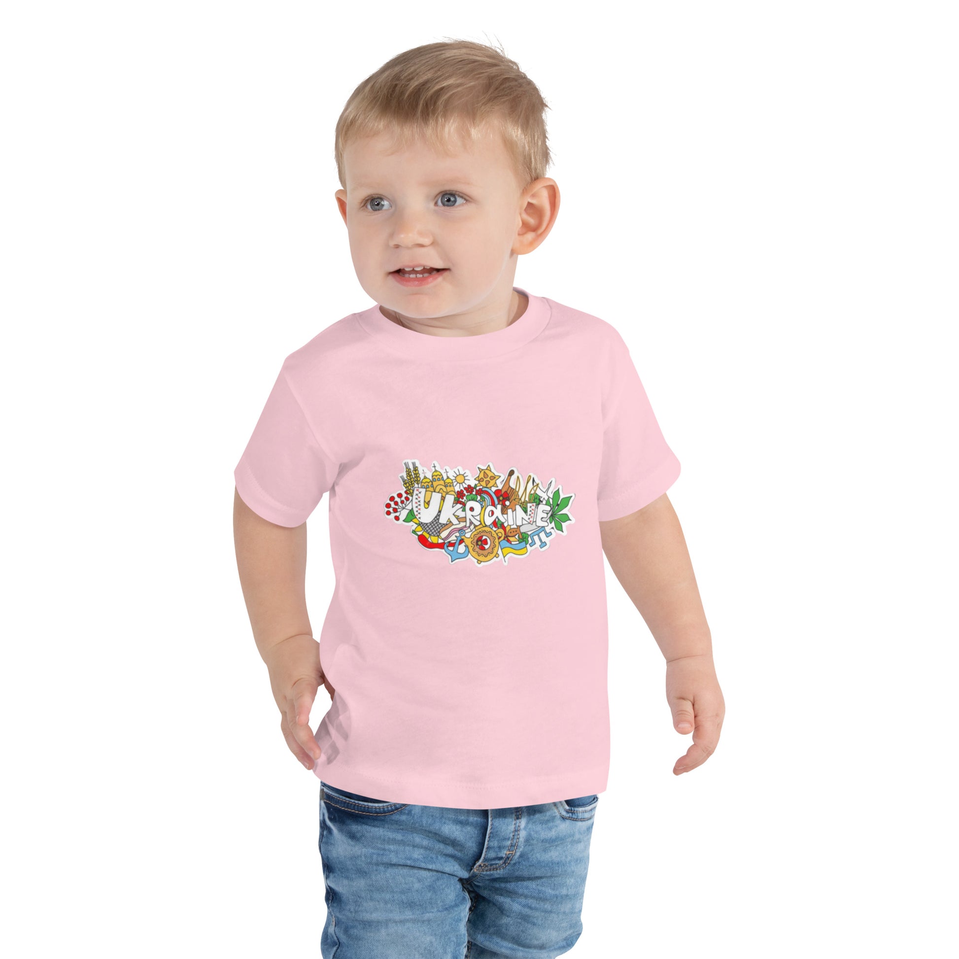 Toddler wearing a pink short sleeve T-shirt with colorful Ukraine design graphic.