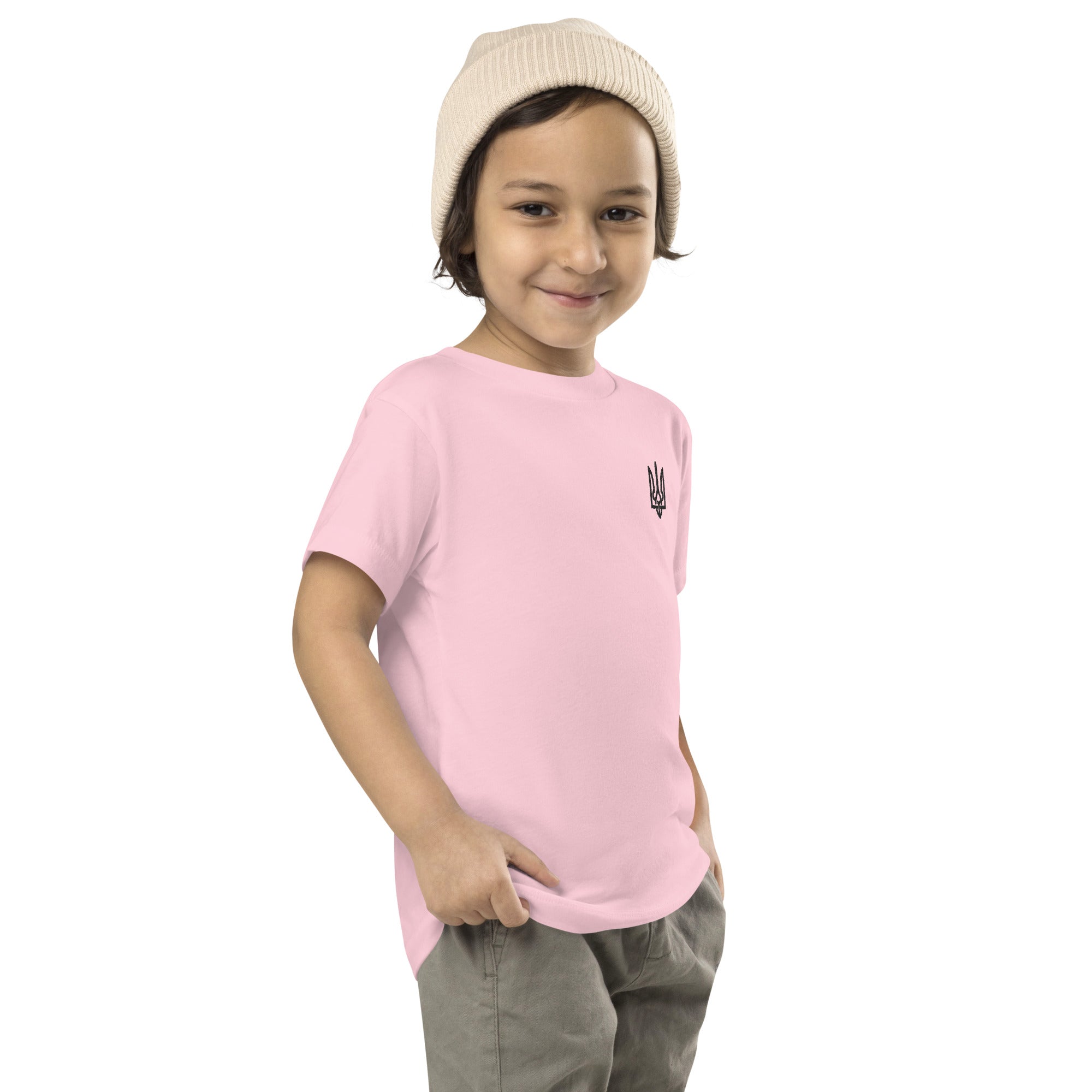 Toddler wearing a pink short sleeve tee with Ukrainian Tryzub print, featuring soft and durable cotton fabric, ideal for active play.