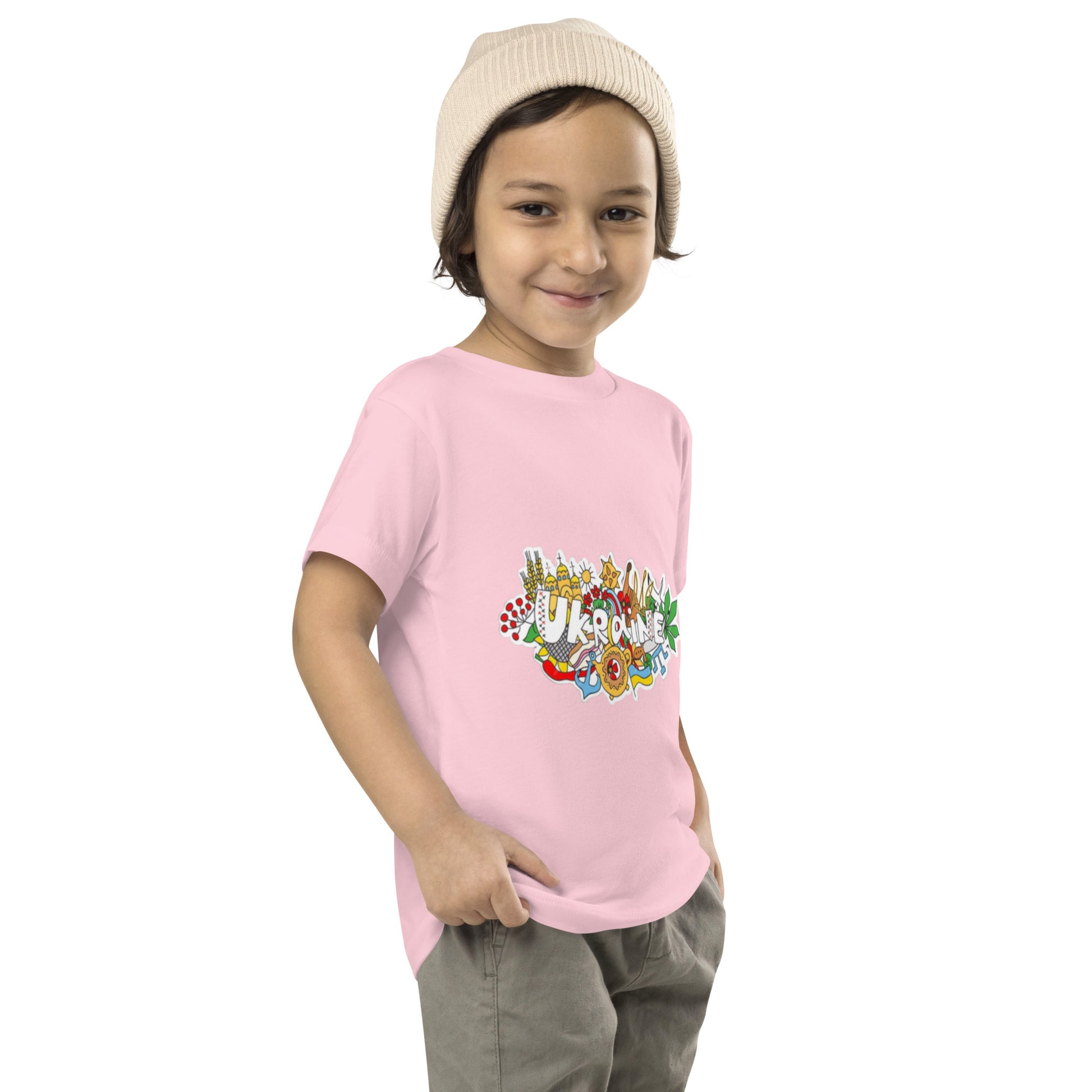 Toddler wearing a pink short sleeve T-shirt with Ukraine design, showcasing cultural print, made from 100% cotton for comfort and style.