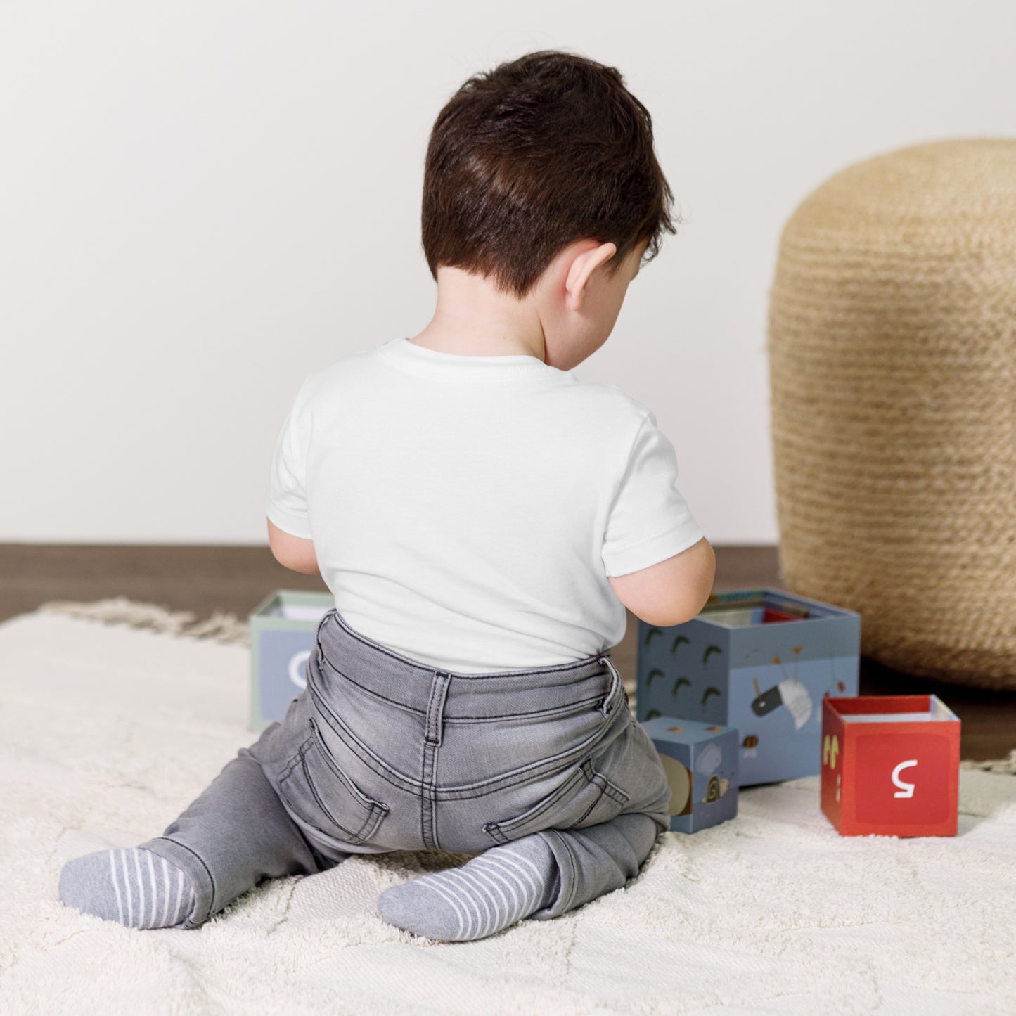 Toddler wearing a short sleeve Ukraine design tee, playing on a soft rug with colorful blocks, showcasing comfort and style.