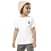 Toddler wearing a white short sleeve tee with Ukrainian Tryzub print, paired with khaki pants and a beige beanie.