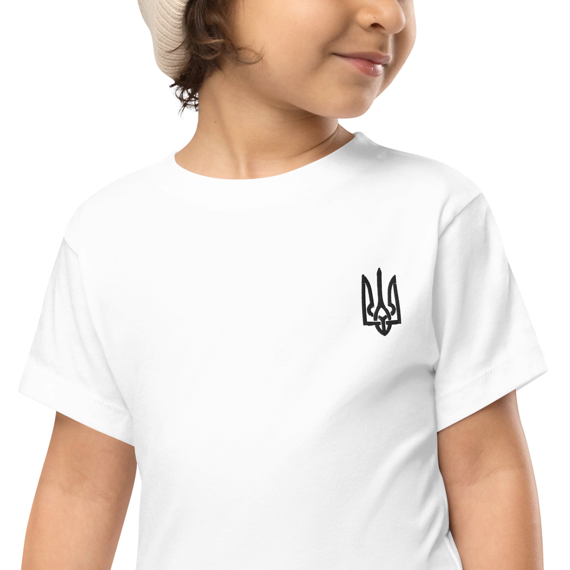 Toddler wearing a white short-sleeve tee with Ukrainian Tryzub print, perfect for comfort and play.