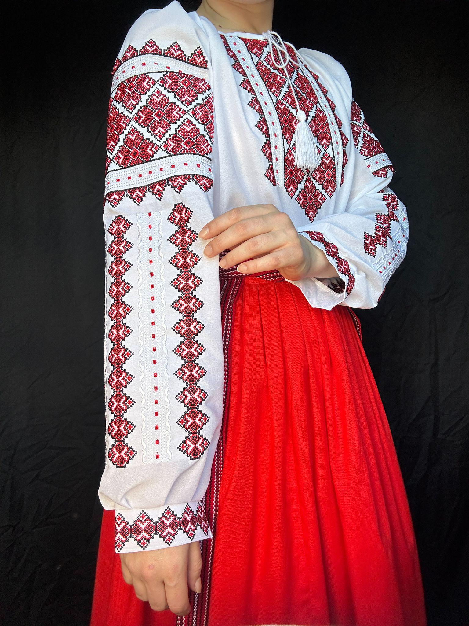 Traditional Ukrainian Vyshyvanka blouse with red embroidery, ethnic cross-stitch design on white chiffon fabric.
