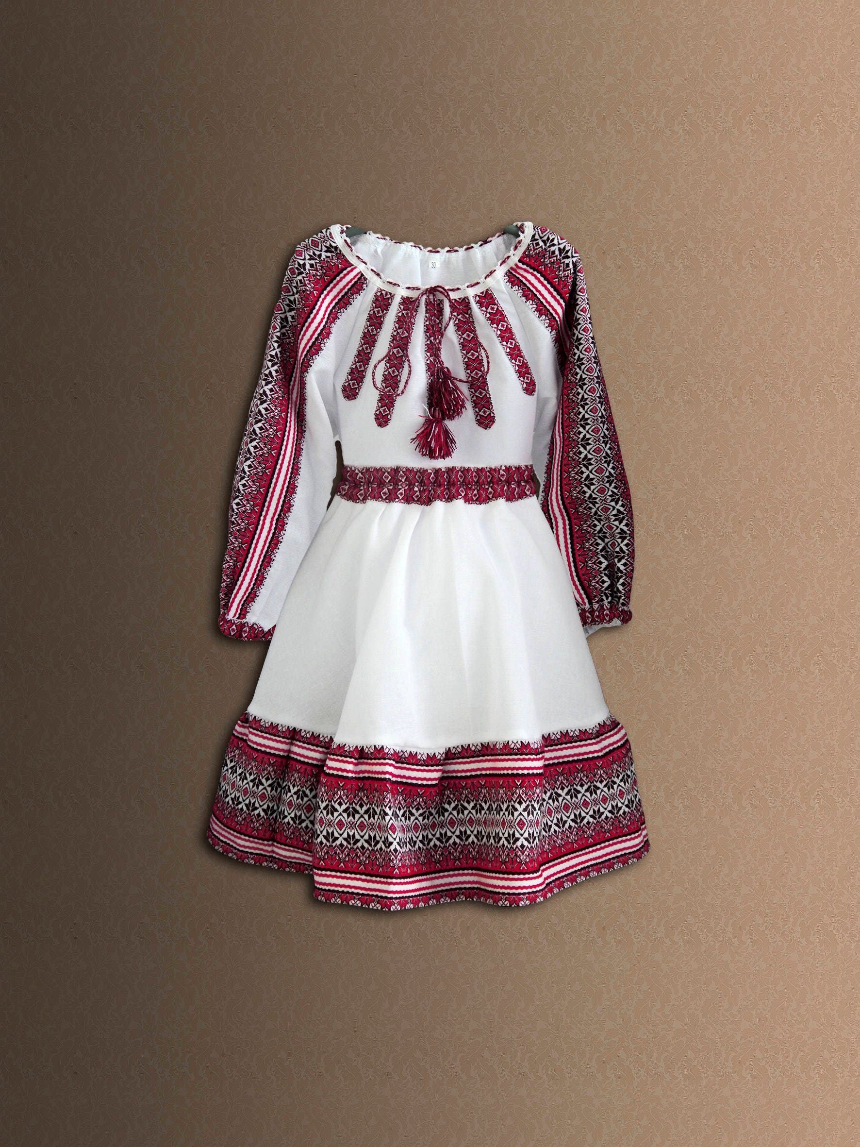 Traditional Ukrainian embroidered girl's costume with folk cotton blouse and skirt, showcasing vibrant cultural patterns.