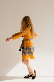 Girl wearing a traditional Ukrainian golden dress with blue and white embroidery, showcasing cultural elegance and modern comfort.