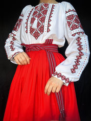 Traditional Ukrainian embroidered Vyshyvanka blouse with red cross-stitch patterns, paired with a matching red skirt.