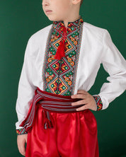 Boy wearing traditional Ukrainian Vyshyvanka shirt with colorful embroidery, paired with red pants.