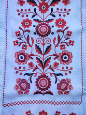 Traditional Ukrainian wedding rushnyk with red floral embroidery design on white linen fabric.