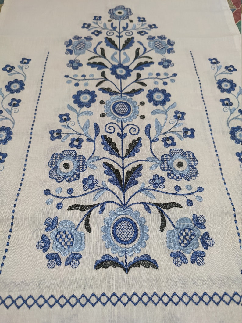 Traditional Ukrainian wedding rushnyk with blue Tree of Life embroidery on white linen, cultural and rustic home decor.