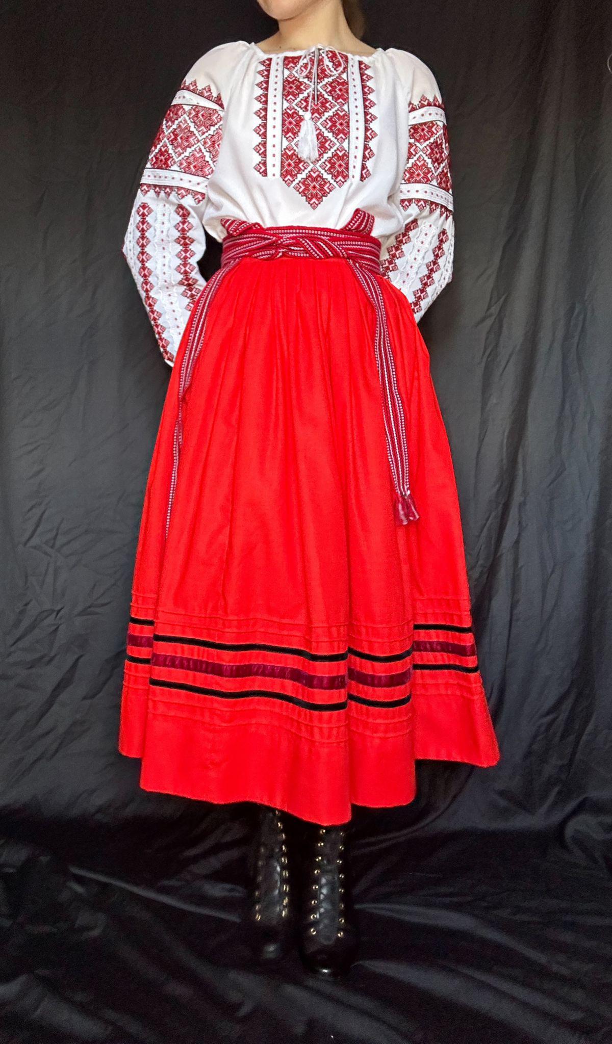 Woman wearing traditional Ukrainian Vyshyvanka blouse with red embroidered skirt.