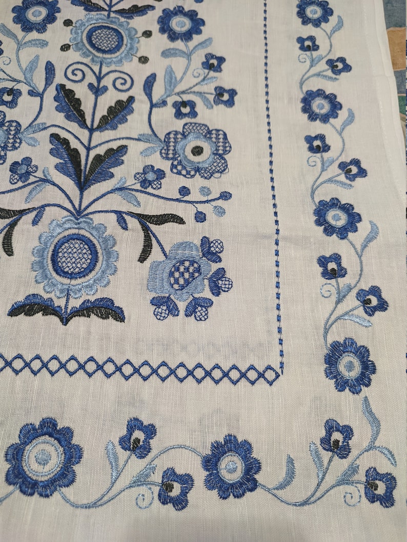Blue embroidered Ukrainian rushnyk with floral Tree of Life motif on 100% linen fabric, symbolizing prosperity and protection.