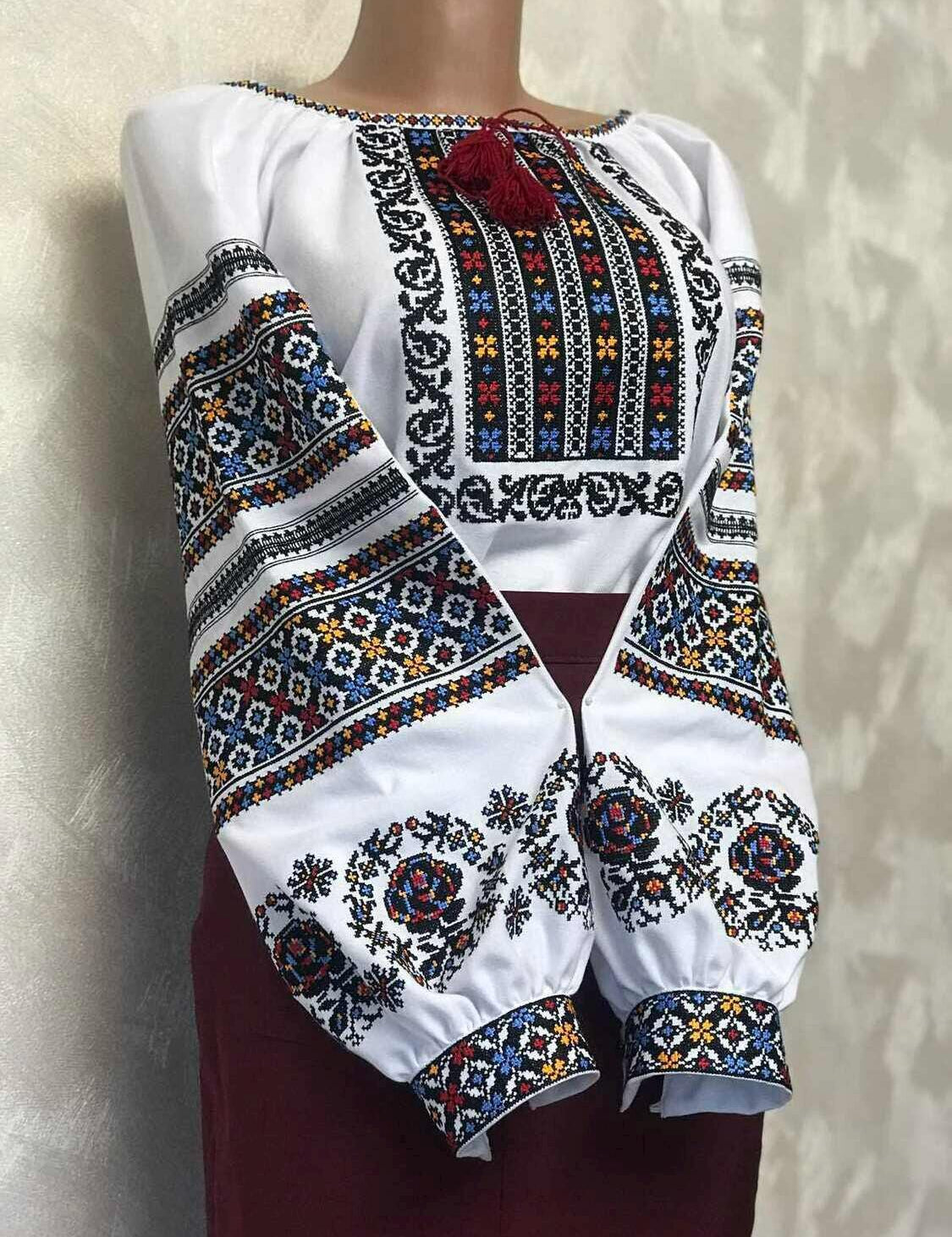 Women's Ukrainian vyshyvanka embroidered blouse with traditional ethnic patterns on homespun fabric, featuring vibrant cross-stitch.