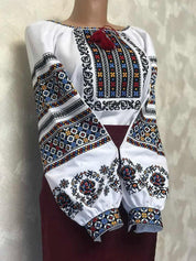 Women's Ukrainian vyshyvanka embroidered blouse with traditional ethnic patterns on homespun fabric, featuring vibrant cross-stitch.