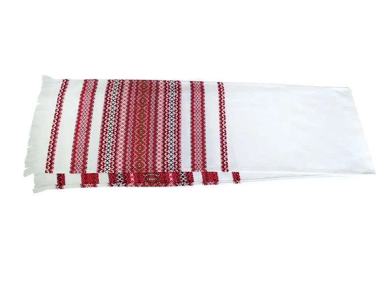 Traditional Ukrainian rushnyk with red and black Slavic embroidery on woven cotton, symbolizing culture and unity in weddings.