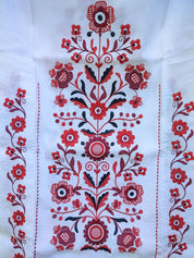 Traditional Ukrainian rushnyk with red Tree of Life embroidery on linen, symbolizing prosperity and protection.