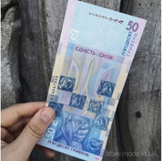Limited edition Ukraine 50 UAH banknote "Unity Saves the World" held against a wooden background