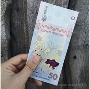 Limited edition Ukraine 50 UAH commemorative banknote "Unity Saves the World" in hand, featuring unique design elements.