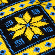 Close-up of knit scarf with traditional yellow and blue geometric pattern inspired by Ukrainian artistry for winter warmth.