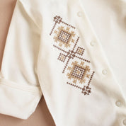 Ukrainian embroidered baby romper with beige-brown Vyshyvanka patterns, perfect for newborns and baby showers.