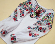 Ukrainian embroidered blouse for girls with vibrant floral cross-stitch design, perfect for cultural events and photo sessions.