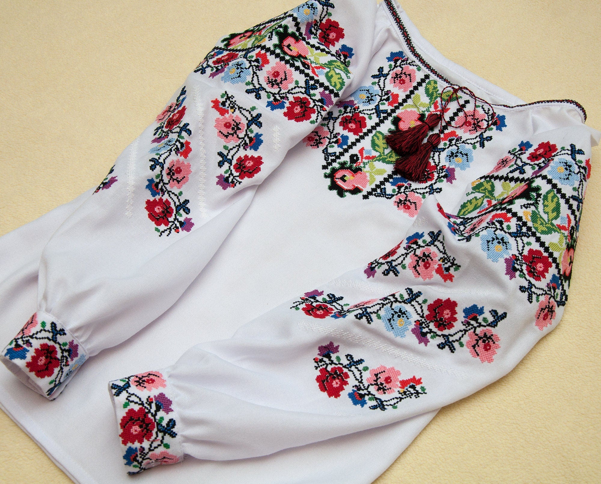 Ukrainian embroidered blouse for girls with vibrant floral cross-stitch design, perfect for cultural events and photo sessions.