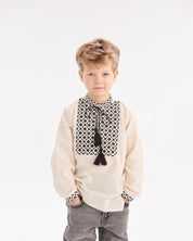 Boy wearing Ukrainian embroidered shirt in Slavic folk style with black and white pattern, suitable for heritage celebrations.