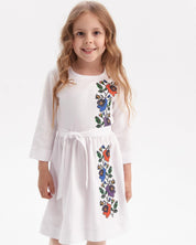 Girl wearing Ukrainian embroidered dress with floral designs, traditional kids vyshyvanka, celebrating Slavic heritage.