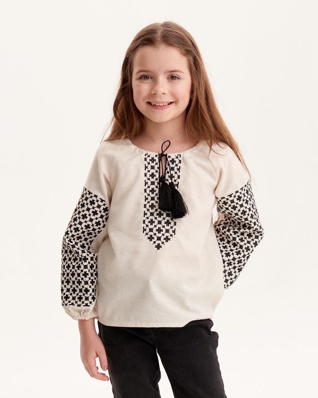 Young girl wearing Ukrainian embroidered vyshyvanka blouse with traditional Slavic patterns, perfect for cultural events or everyday wear.