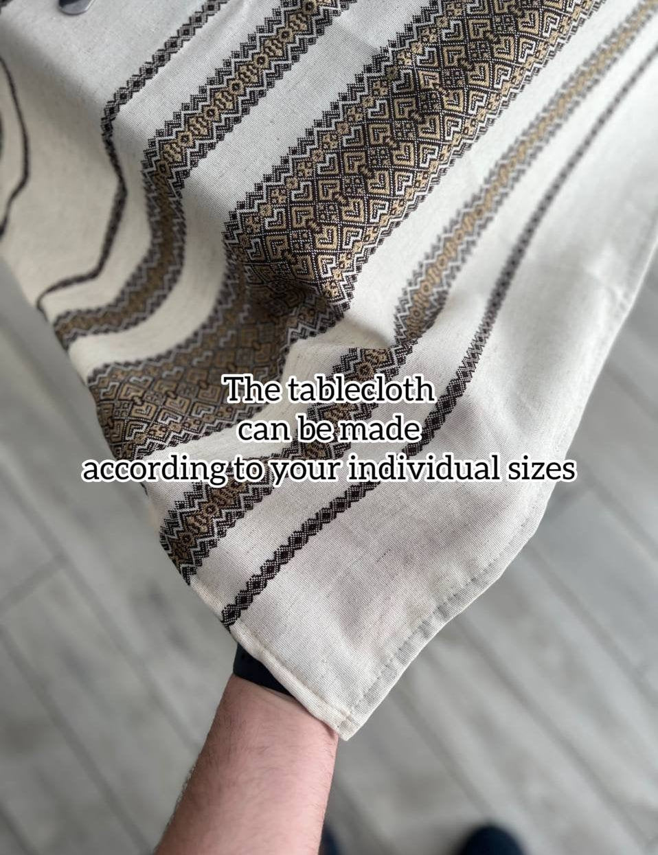 Ukrainian embroidered linen tablecloth held up to show ethnic pattern and custom sizing options