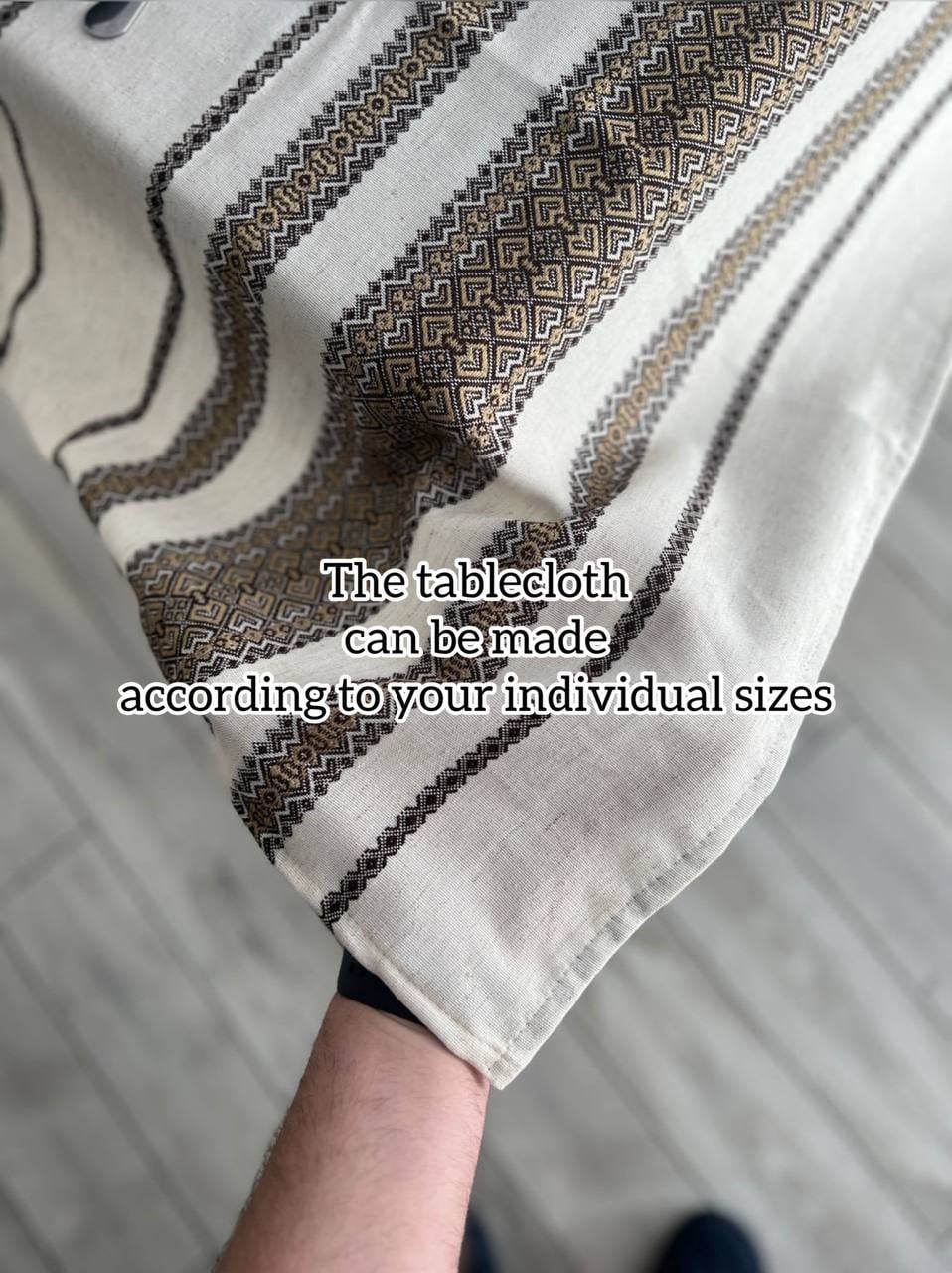 Ukrainian embroidered linen tablecloth held up to show ethnic pattern and custom sizing options